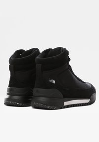 Černé středně vysoké tenisky s kombinací tkaniny a semiše, vybavené texturovanou podrážkou a logem na patě. Šněrování pro bezpečné uchycení.