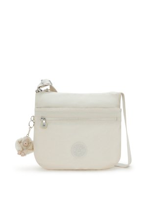 Lys beige crossover taske lavet af stof, med en front lynlåslomme, logo emblem og en aftagelig plyssaberat charme.