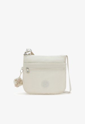 Bolso bandolera color beige claro hecho de tela, que cuenta con un bolsillo frontal con cremallera, un emblema de logo y un charm de mono de peluche desmontable.