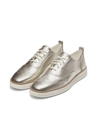 Un paio di sneaker brogue in metallo argento con lacci, dettagli perforati e suole in gomma bianca, su uno sfondo bianco.