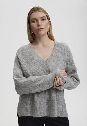 Hellgrauer Strickpullover mit tiefem V-Ausschnitt und weiten, langen Ärmeln, der eine weiche Textur und seitliche Schlitze am Saum aufweist.