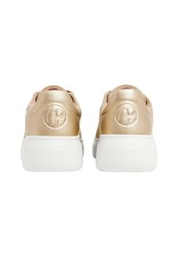 Baskets métalliques dorées avec une finition lisse, dotées d'une semelle blanche et d'un logo embossé sur le talon. Forme arrondie, détails de design minimalistes.