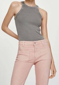 Top de tirantes gris de canalé con un escote alto, combinado con unos jeans de mezclilla rosa claro que cuentan con bolsillos frontales y cierre de botón.