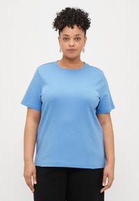 T-shirt de algodão azul com decote redondo, mangas curtas e um corte descontraído. Textura suave sem padrões ou detalhes visíveis.