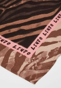 Sciarpa marrone e beige con un design a strisce simile a quello di una zebra, caratterizzata da un bordo rosa con testo nero lungo il margine. Morbida al tatto, di forma triangolare.