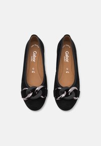 Ballet flats in suede nera con punta tonda e una fibbia decorativa a catena. Presentano una soletta imbottita e una fodera interna liscia e a contrasto.