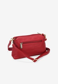 Borsa a tracolla rossa in pelle con superficie texturizzata, dotata di una tasca con zip anteriore e dettagli in hardware dorato. Include una tracolla regolabile.
