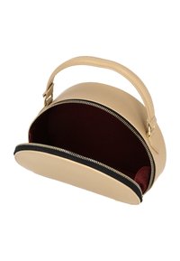 Bolso de cuero beige con forma redondeada, que cuenta con un asa superior y una cremallera negra en contraste. El interior está forrado con tela de un profundo color rojo.