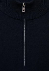 Navy knitted sweater with a high collar and silver zipper. Features ribbed texture and a straight cut design.