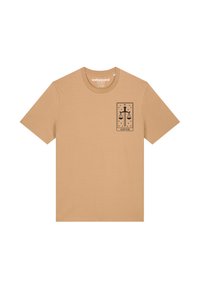 Beige katoenen t-shirt met een zwart grafisch ontwerp van schubben en een zwaard, gelabeld "JUSTICE," op de linker borst. Korte mouwen.