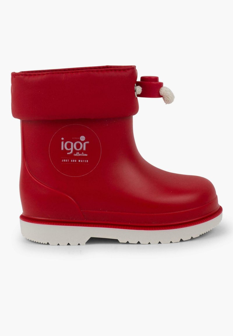 Bota de lluvia de goma roja con suela blanca, parte superior enrollada y un pequeño toggle adjunto para ajustar. Presenta un logo circular en el costado.