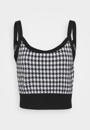 Sort og hvid cropped tanktop med houndstooth mønster, ribbet kant forneden og justerbare stropper. Blød tekstur hele vejen igennem.