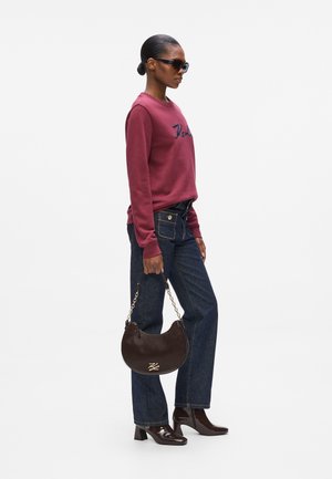 Burgundy sweatshirt with embroidered lettering, dark denim jeans, a round brown leather handbag with chain, and patent leather boots.