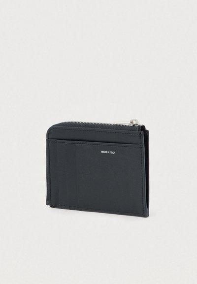 Portefeuille noir en cuir lisse, doté d'une fermeture éclair, de plusieurs emplacements pour cartes et d'une inscription logo argentée. Forme compacte et rectangulaire.