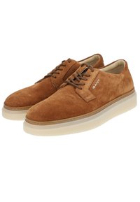 Braune Wildleder-Schnürschuhe mit runder Spitze und einer dicken, hellen Gummisohle. Verfügt über feine Nähte und ein Logo an der Seite.