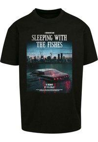 Sort bomulds T-shirt med et grafiktryk af en nedsænket bil i en bylandskab ved skumringstid, med hvid og rød tekst over og under billedet.