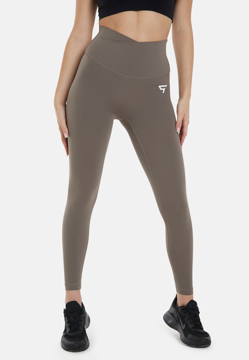 Hoge taille leggings in een gedempte taupe kleur, gemaakt van een gladde, rekbare stof, met een klein wit logo op de heup en een enkel lengte pasvorm.