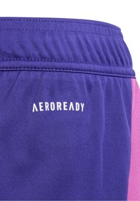 Pantalones cortos deportivos morados con cintura elástica, logo "AEROREADY" en blanco y una tela texturizada con acentos rosas.