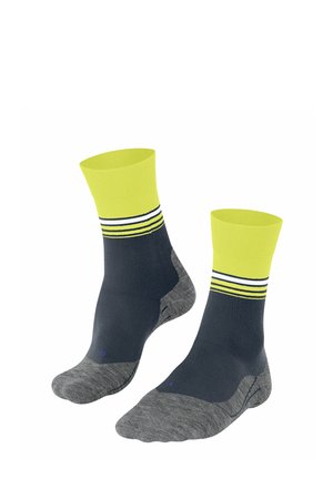 Calzini alla caviglia blu navy e grigi con polsini gialli brillanti e strisce bianche. Presentano una suola imbottita per comfort e supporto.