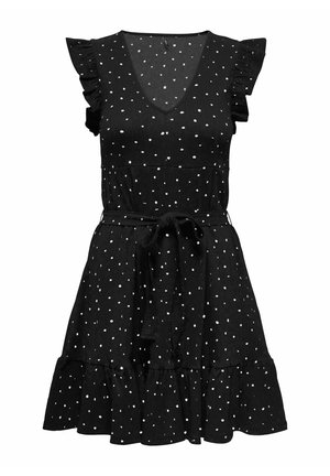 Robe noire sans manches à pois blancs, encolure en V, épaules et ourlet à volants, ceinture nouée à la taille.