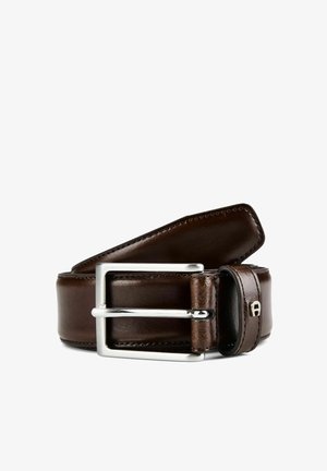 Cintura in pelle marrone scuro con fibbia rettangolare in argento lucidato, arrotolata e fissata con un anello in pelle su sfondo bianco.