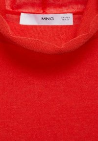 Maglione rosso a maglia con una texture morbida e un collo alto. Presenta un design semplice e senza cuciture con un'etichetta che mostra il nome del marchio MNG.