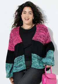 Sweter wykonany na drutach z blokami kolorów różowego, czarnego i turkusowego. Luźny, oversize'owy krój z szerokimi rękawami i głębokim dekoltem w kształcie litery V.