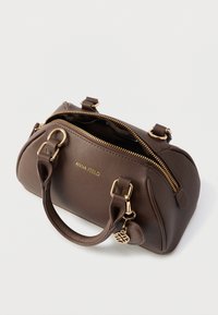 Hnedá syntetická kabelka so zlatými kovovými doplnkami, uzatváraním na zips a krátkymi rúčkami. Na boku je logo a prívesok ako ozdoba.