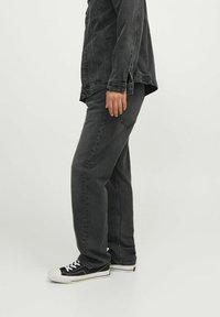 Svarta denimjeans med rak passform, åtföljda av en matchande svart denimjacka. Funktioner inkluderar sydda sömmar och framfickor.