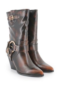 Botas de cuero marrón hasta el tobillo con punta afilada, que presentan un puño ancho, una hebilla decorativa y un tacón en cuña. Textura suave con acabado pulido.