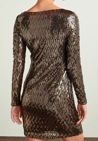Robe à sequins avec manches longues, présentant des rangées verticales de sequins bronze, or et argent. Coupe ajustée, longueur au-dessus du genou.