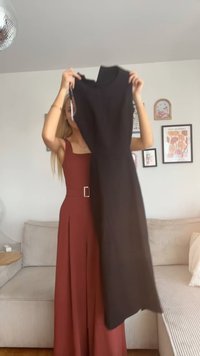 Svart ärmlös klänning med hög halsringning och åtsittande silhuett, visad mot en mjuk, ljus bakgrund.