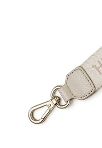 Sangle beige avec un attachement en cuir, dotée d'un fermoir en métal doré. La sangle présente une texture avec un motif subtil et un détail de marque.