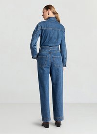 Jeans-Outfit mit einem Hemd mit Kragen und hoch taillierter Hose in mittlerem Blauton. Auffällige Taschen auf der Rückseite und lockere Passform.