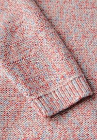 Maglione lavorato a maglia in una sfumatura pastello di rosa, rosso e blu. Presenta una superficie testurizzata e polsini a coste per un tocco di dettaglio in più.