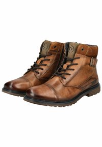 Botas de tobillo de cuero marrón con un acabado texturizado, puntera redonda, diseño de cordones y cuello de textil. Presenta un logotipo en la lengüeta y una correa ajustable.