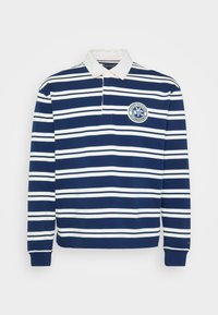 Marineblå og hvitstripet langermet polo skjorte med hvit krage og sirkulært "NYC Columbus Avenue"-logo på brystet.