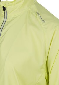 Lightweight, bright yellow jacket with a high collar, silver zipper, and branding. Smooth fabric with a subtle patterned texture.