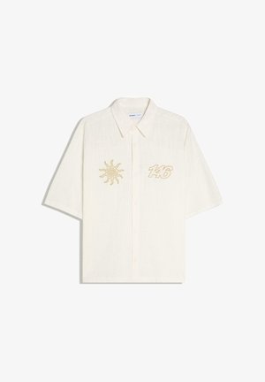 Biała koszula z krótkim rękawem, zapinana na guziki z kołnierzykiem, z motywem słońca na lewej piersi oraz numerem 146 na prawej piersi, wykonanym żółtym ściegiem.