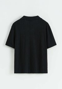 Chemise noire à manches courtes avec un motif en losanges texturé, dotée d'un col soigné et d'une coupe décontractée. Le tissu a une finition lisse.