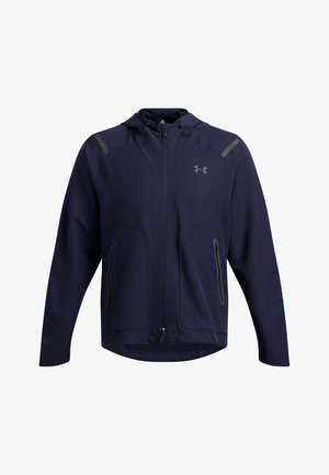 Marineblauwe sportjas met capuchon, rits aan de voorkant, twee zijzakken en grijze accenten op de schouders. Gemaakt van lichtgewicht, flexibel materiaal.