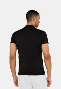 Maglietta nera a maniche corte con una texture liscia e un design aderente. Presenta un classico collo a giro e semplici dettagli sul retro.