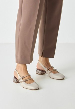 Zapatos de piel beige con tiras traseras, punta cuadrada, dos correas ajustables y tacón cuadrado con estampado en tonos marrón y crema.