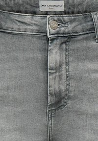 Vaqueros de mezclilla gris vista frontal con botón y etiqueta con la marca "ONLY CARMAKOMA Denim".