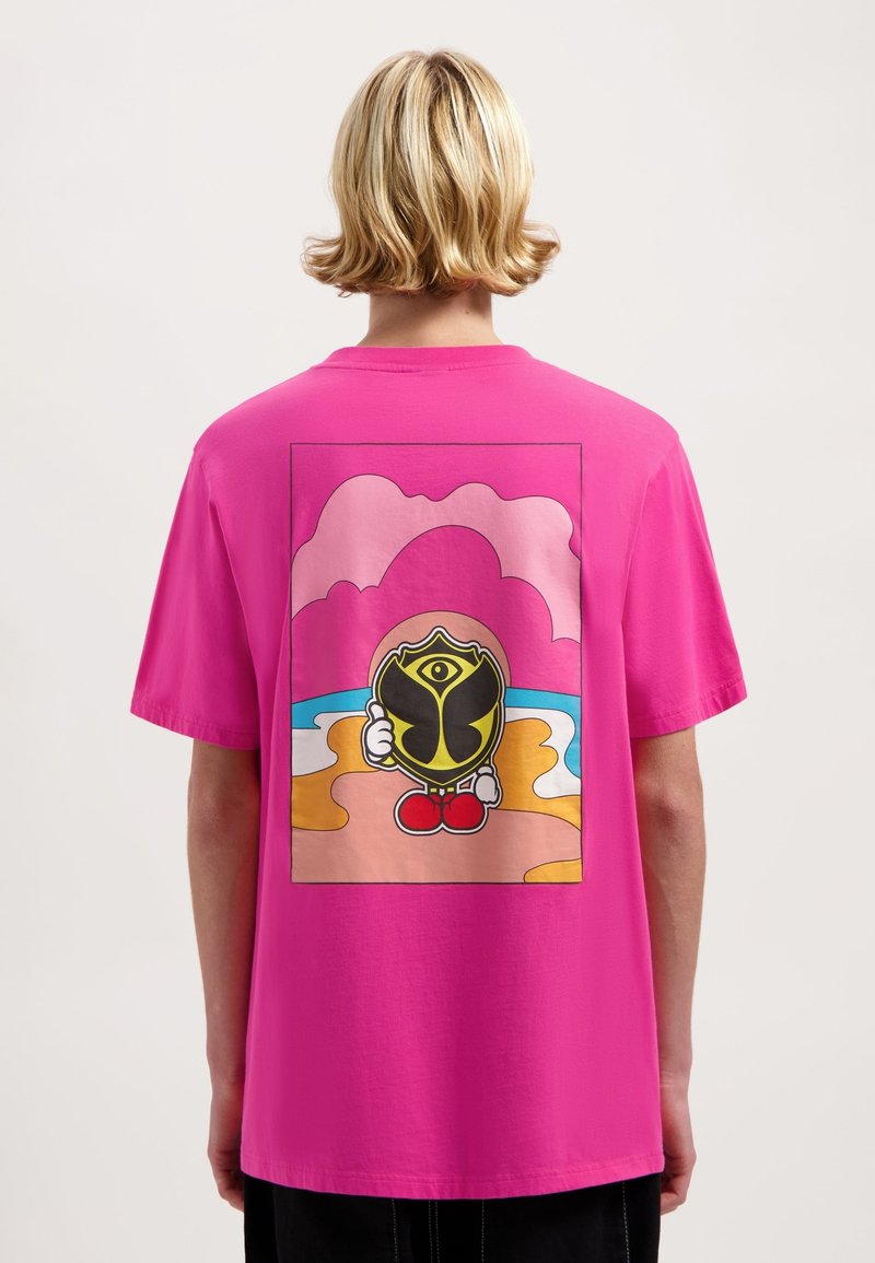 Roze katoenen T-shirt met een grote cartoonafbeelding op de achterkant, waarop een figuur met een schild en een kleurrijke strandachtergrond is afgebeeld.