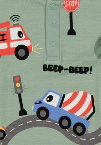 Vihreä puuvillainen potkupuku, jossa on sarjakuvamaisia ajoneuvoja, kuten paloauto ja betonimylly, ja joka sisältää värikkäitä yksityiskohtia sekä leikkisän tekstin "BEEP-BEEP!"