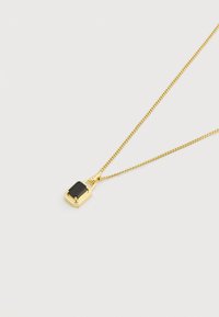 Κολιέ με χρυσή αλυσίδα και ορθογώνιο μαύρο πολύτιμο λίθο που είναι τοποθετημένος σε χρυσή βάση σε λευκό φόντο.