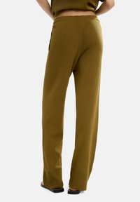 Zielono-oliwkowe, dzianinowe spodnie typu wide-leg z wysokim stanem i prążkowanymi mankietami, charakteryzujące się gładkim, teksturowanym wykończeniem.