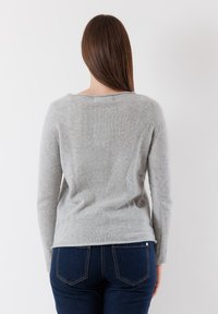 Maglione grigio a maglia con maniche lunghe, scollatura rotonda e una forma leggermente aderente. Texture morbida, con una finitura liscia e senza motivi visibili.