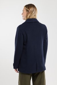 Abrigo de mezcla de lana en color navy con cuello con muesca, abertura trasera y bolsillos laterales. La tela tiene una textura suave y un diseño clásico.